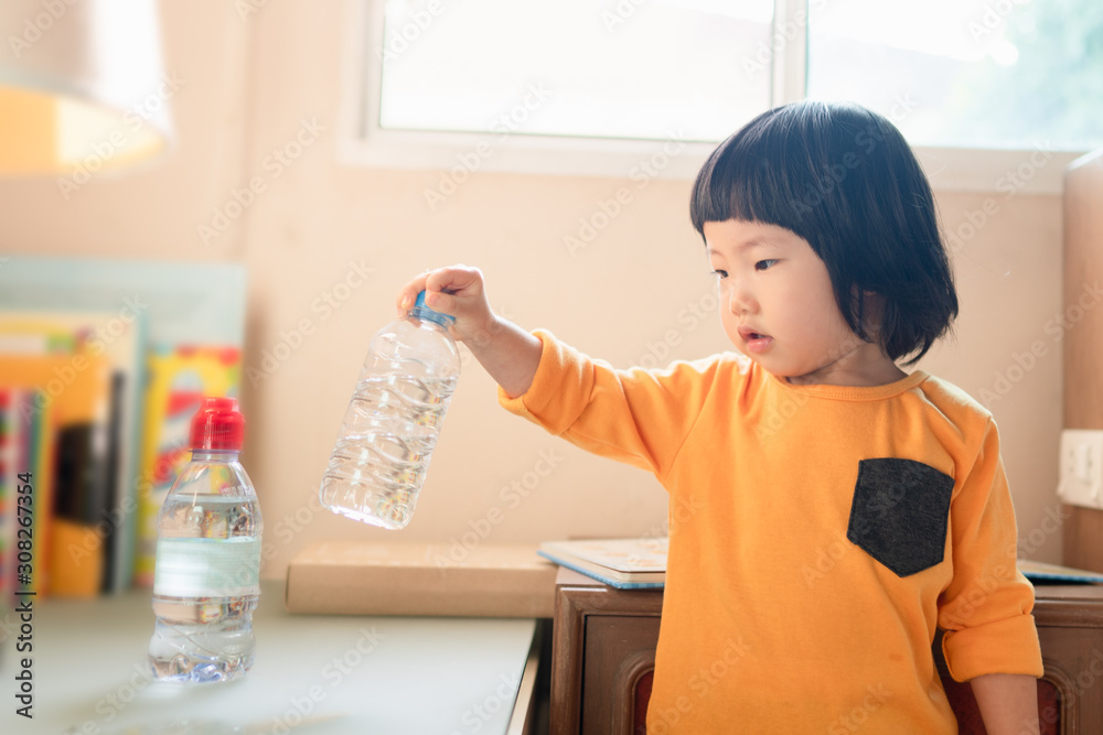 Foto Stock Cute 2 year old Asian toddler girl concentrates lifting