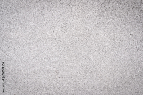 Gray concrete wall texture painted with white. The old white color that has been fading and peeling off. Texture of old dirty concrete wall for background.
