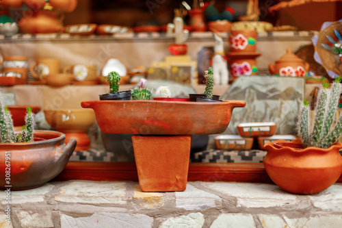 Close-up of orange ceramic vessels in the window of a souvenir shop
