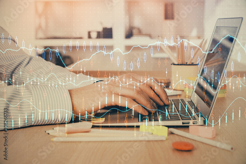 Double exposure of stock market graph with man working on laptop on background. Concept of financial analysis.