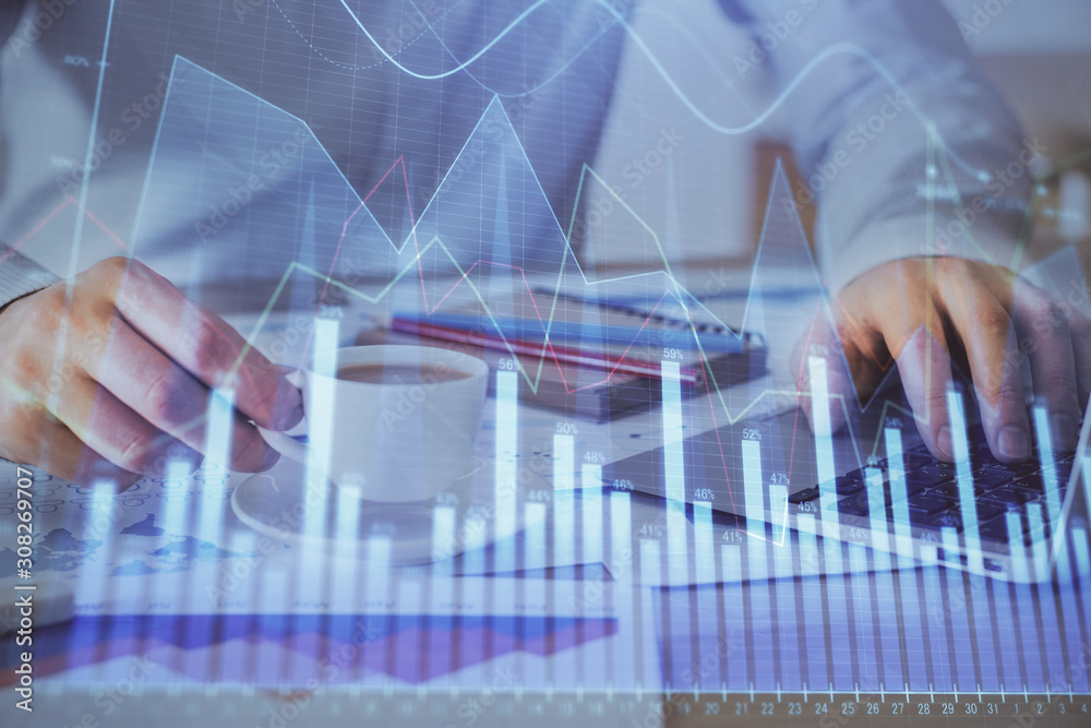 Forex graph with businessman working on computer in office on background. Concept of hardworking. Double exposure.