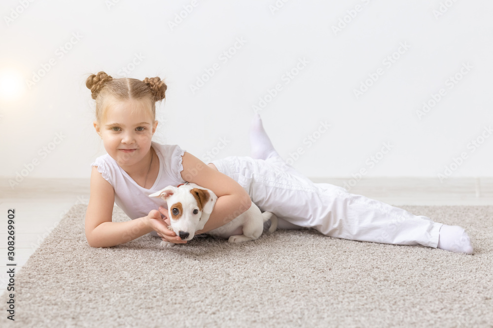 people, children and pets concept - little child girl lying on the floor with cute puppy Jack Russell Terrier people, children and pets concept - little child girl lying on the floor with cute puppy Jack Russell Terrier