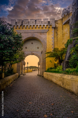 Sintra Pena palace popular destination with dramatic sky during winter sunset in Portugal with colorful buildings photo