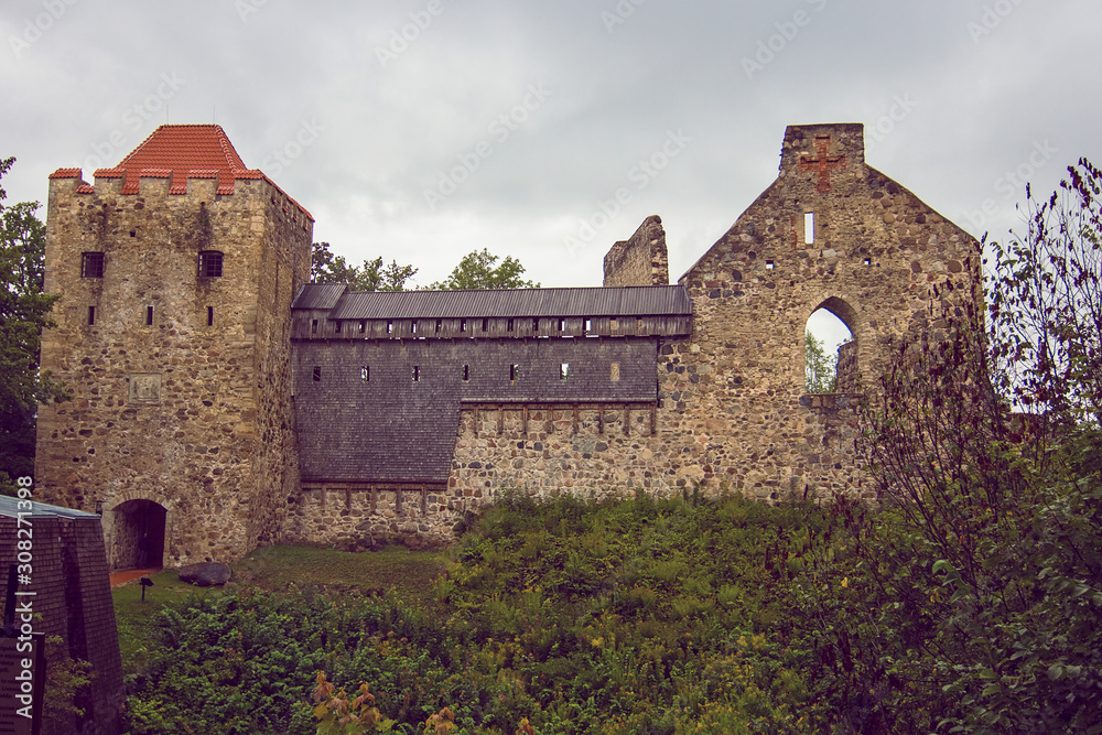 Fototapeta premium Ruins of ancient Sigulda Medieval Castle, Latvia. It was built at an early stage of the conquest of the Baltic states by the crusaders. Summer cloudy and rainy day. Soft focus.