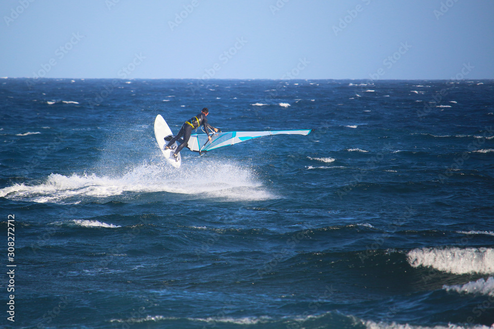 Windsurfer performing a Freestyle move in the wave of the Atlantic ocean (El Medano, Spain)