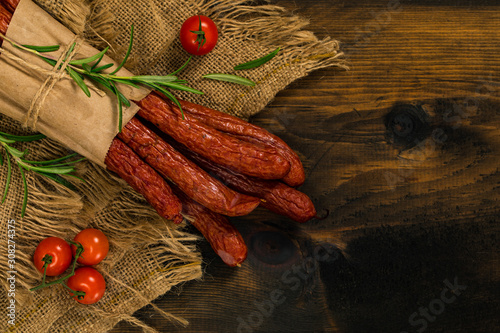 Kabanos or Cabanossi Thin Dry Smoked Polish Sausage on Wooden Background. Selective focus. photo