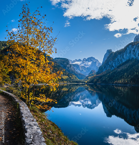 Fototapeta Naklejka Na Ścianę i Meble -  Peaceful autumn Alps mountain lake. Gosauseen or Vorderer Gosausee lake, Upper Austria. Dachstein summit and glacier in far.