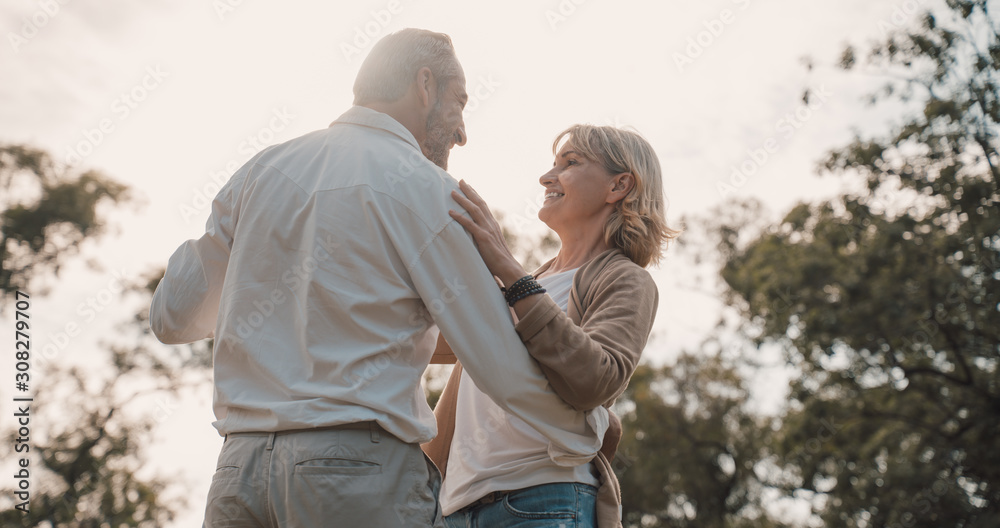 Older Lover and dating concept.Beautiful Senior couple romantic dancing in park.mature couple in summer park.Elderly man and old woman in love dancing outdoors. Older Lover and dating concept.Beautiful Senior couple romantic dancing in park.mature couple in summer park.Elderly man and old woman in love dancing outdoors.