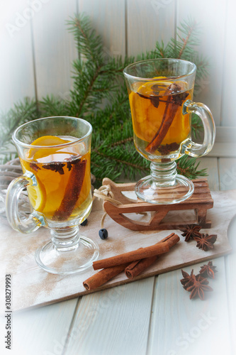 Mulled wine with slice of orange and spices. Conceptual bright card in yellow, blue and white. Vertical image