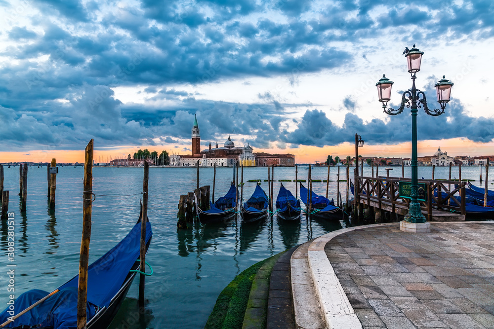 Gondolas docked in Saint Mark square with San Giorgio Maggiore island