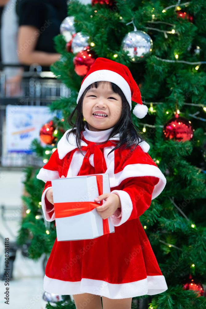 Portrait of cute asian little girl wear santa dress happy near christmas tree,Thailand kid join christmas festival Portrait of cute asian little girl wear santa dress happy near christmas tree,Thailand kid join christmas festival