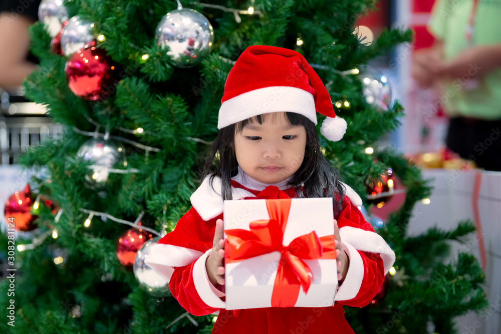 Portrait of cute asian little girl wear santa dress happy near christmas tree,Thailand kid join christmas festival Portrait of cute asian little girl wear santa dress happy near christmas tree,Thailand kid join christmas festival