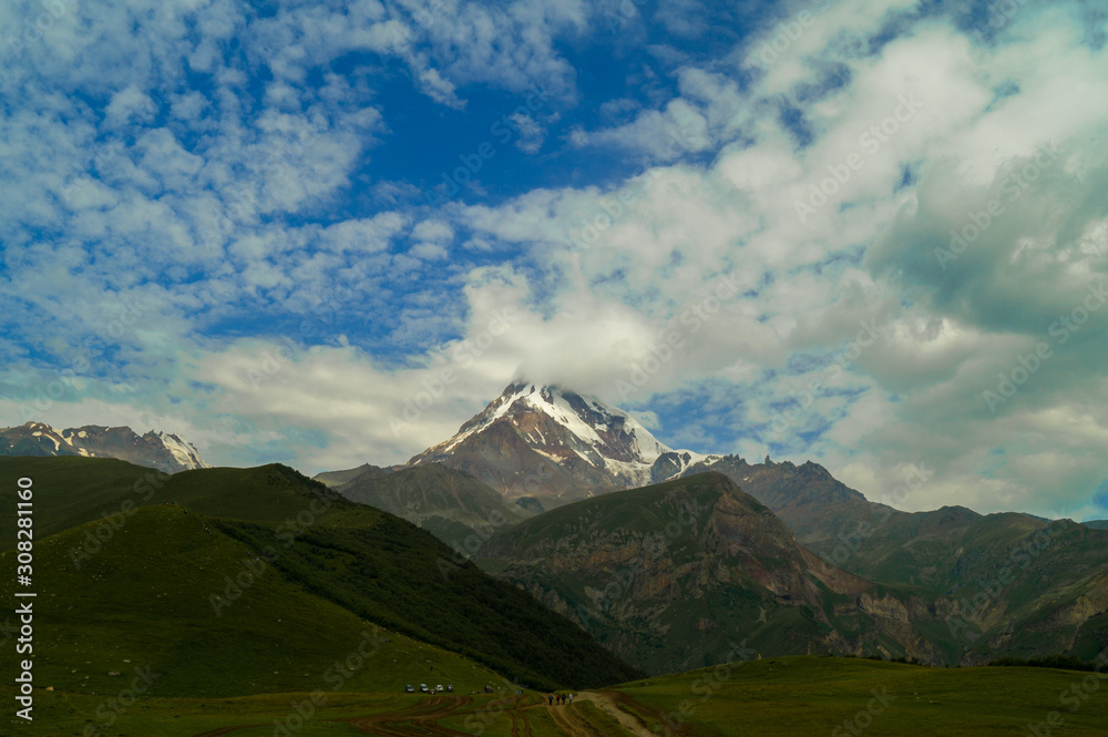  Kazbek. Peak. The highest point of Georgia. High mountain against the sky with clouds.