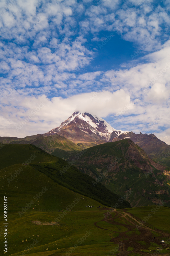 Fototapeta premium Kazbek. Peak. The highest point of Georgia. High mountain against the sky with clouds.