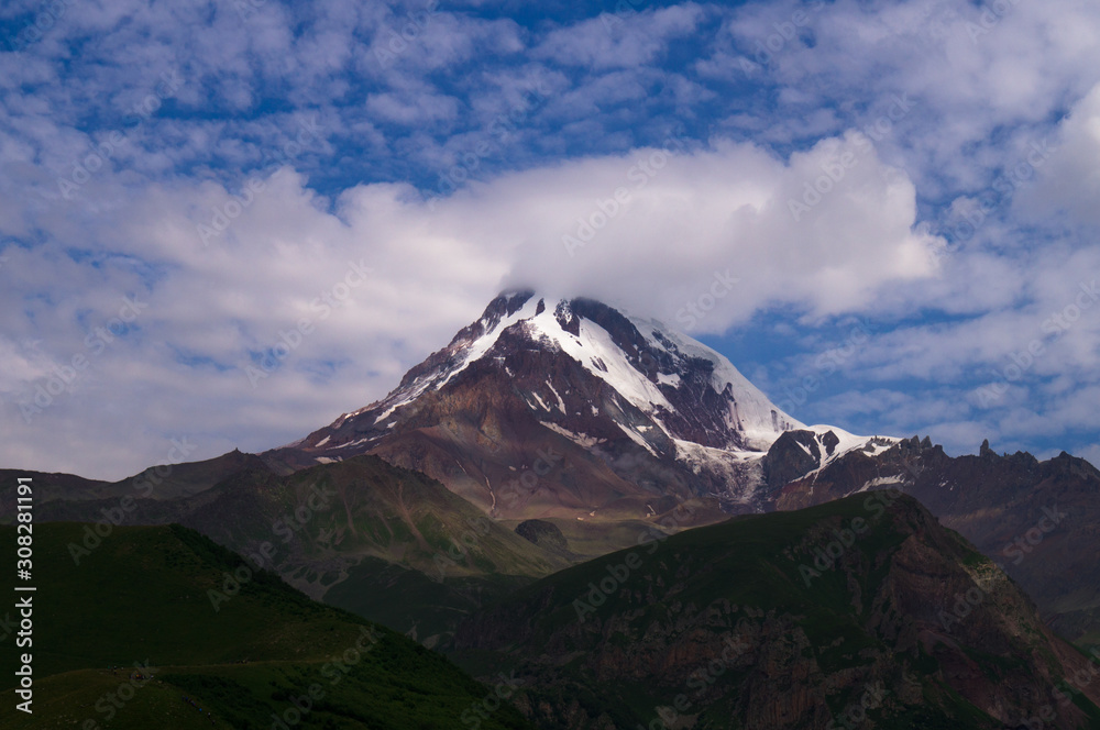  Kazbek. Peak. The highest point of Georgia. High mountain against the sky with clouds.