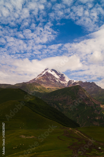  Kazbek. Peak. The highest point of Georgia. High mountain against the sky with clouds.