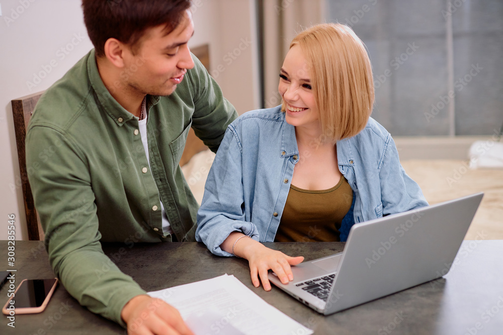 caucasian married couple, handsome man and beautiful woman sit looking for, in search of new house or apartment, mortgage, searching online using laptop caucasian married couple, handsome man and beautiful woman sit looking for, in search of new house or apartment, mortgage, searching online using laptop
