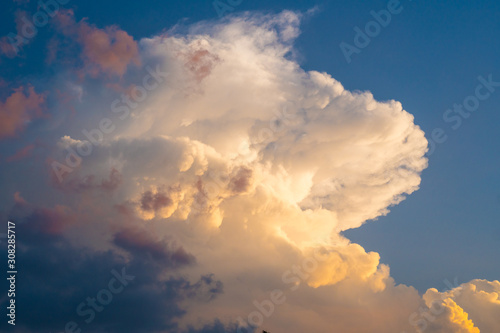Colorful dramatic sky with sunset colors shining through the white clouds © LUMEZIA.com