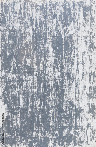 Close-up of a gray wall with white paint badly scratched and peeled off. High resolution full frame abstract background. Copy space.