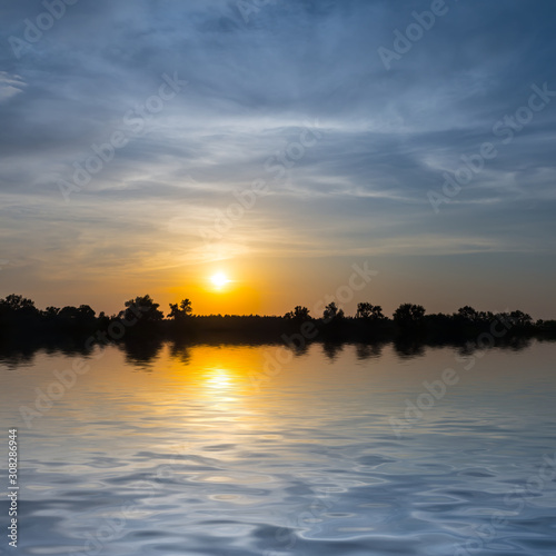 dramatic sunset reflected in a quiet lake  nice outdoor twilight background