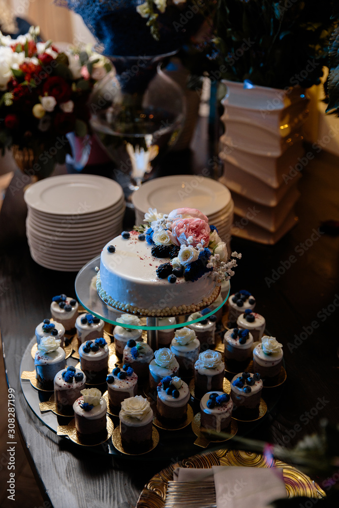 Blueberry with creme decorations wedding reception cake with small cupcakes for guests in Eastern European Baltic Riga Latvia