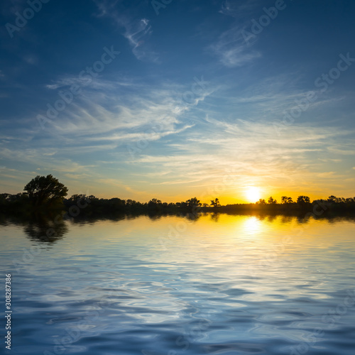 dramatic sunset reflected in a quiet lake, nice outdoor twilight background