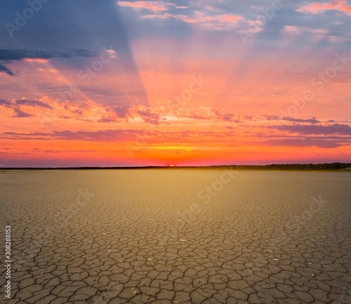dry cracked earth at the dramatic red sunset