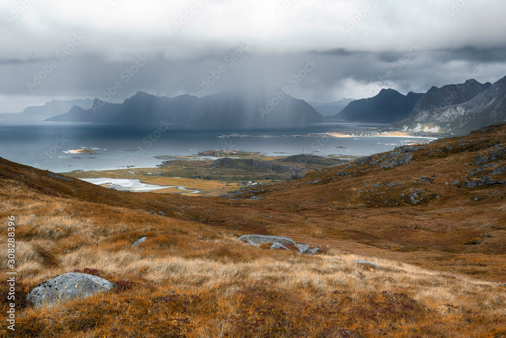 rainy autumn day with storm clouds and the rays of the sun on the way up the mountain Ryten of Norway on Lofoten Islands 