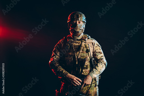 young caucasian military man in camouflage protect people from war, protect his country. brave soldier look at camera isolated in studio