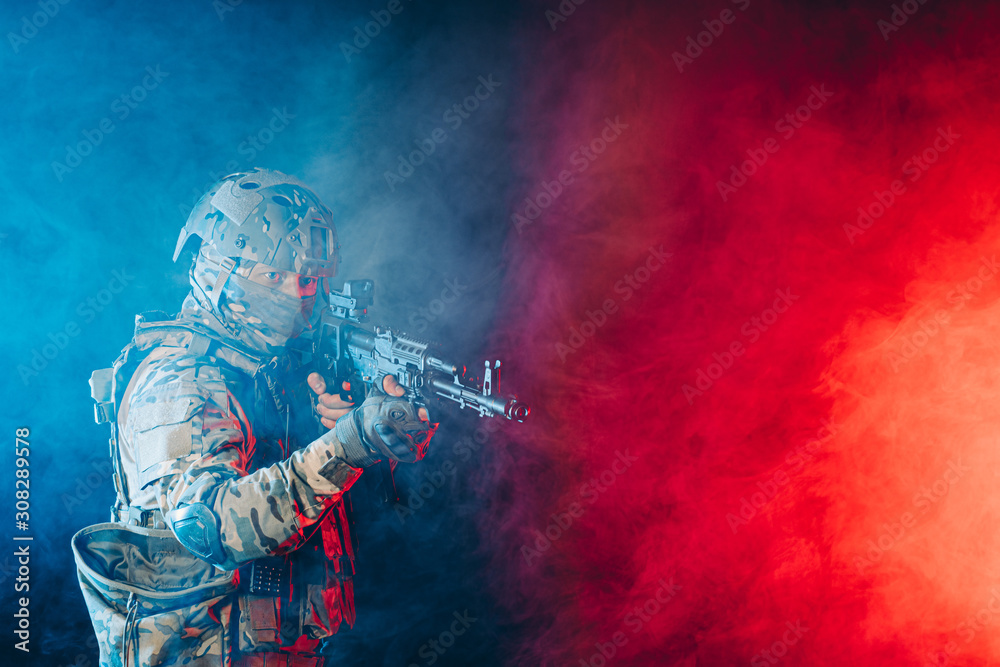 young man in green army wear and helmet shooting rifle at somebody isolated in space with ultra violet rays young man in green army wear and helmet shooting rifle at somebody isolated in space with ultra violet rays