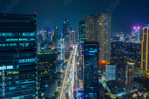 Aerial view of glowing buildings in hectic traffic