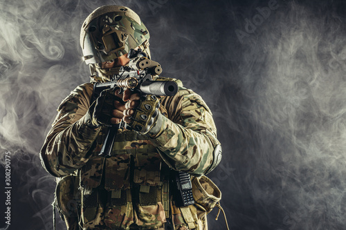 Tableau sur toile special forces soldier man holding machine gun and military equipment in smoky s