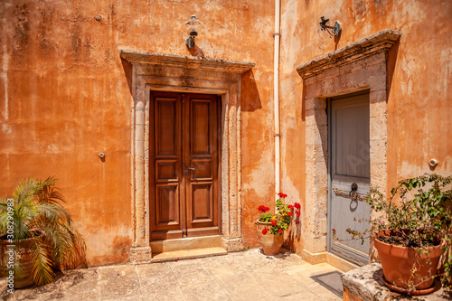 Old courtyard of the monastery with doors and potted flowers