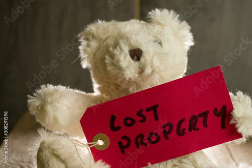 Teddy bear with red label displaying lost property 