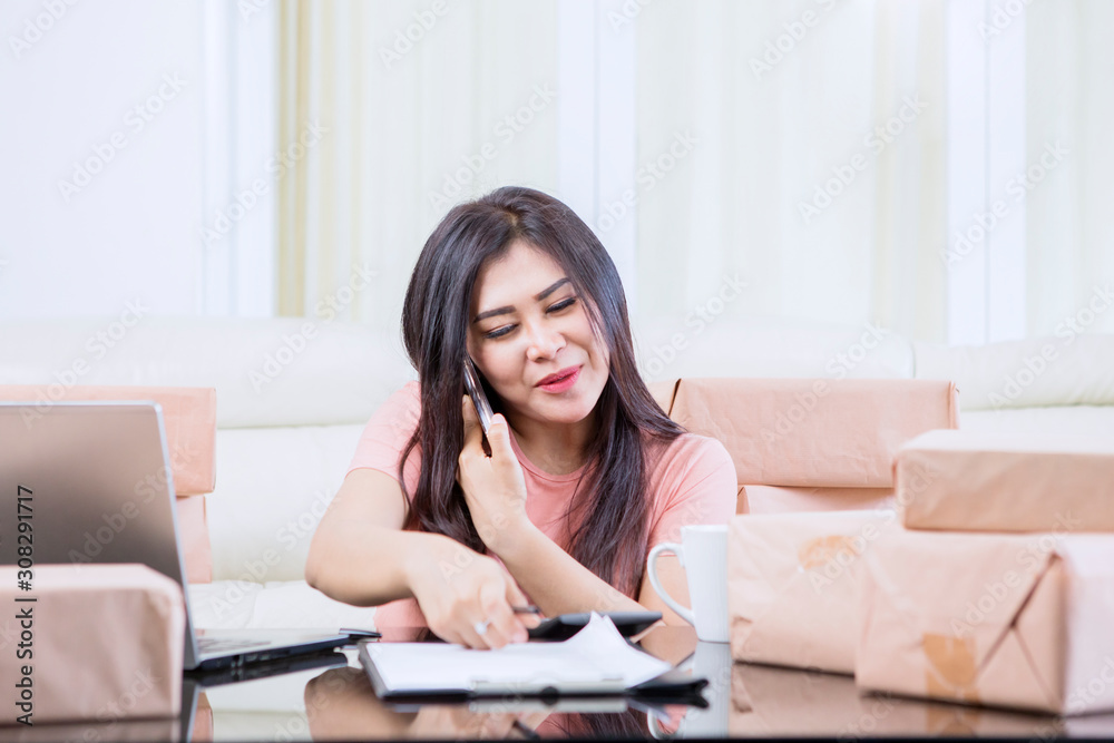 Asian woman multitasking by calling and working Asian woman multitasking by calling and working