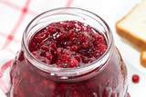 jar of cranberry jam on a white table, top view closeup