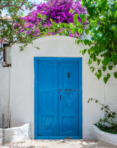 Old blue entrance door in whitewashed wall. © Jakub Rutkiewicz