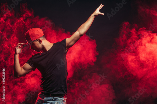handsome man dancing isolated over smoky background, wearing casual wear, street dance
