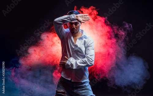 dance as hobby. young man in shirt hold arm near head, posing in studio. isolated
