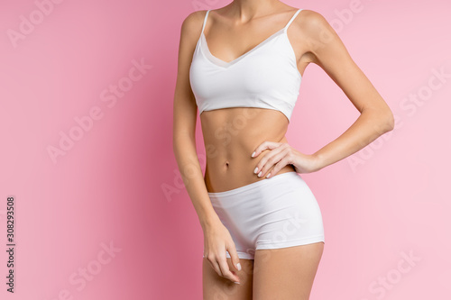 cropped slim beautiful body of young woman wearing underwear and isolated over pink background