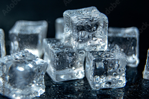 ice cubes on black isolated glass background / ice cold concept