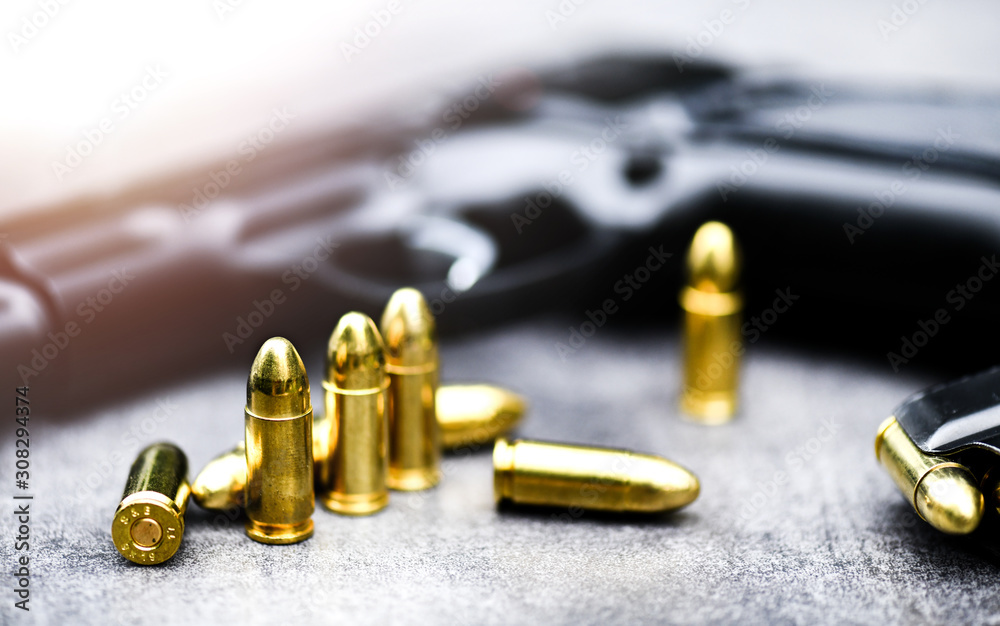 Gun with ammunition on stone background. 9 mm pistol gun weapon and bullets at table.