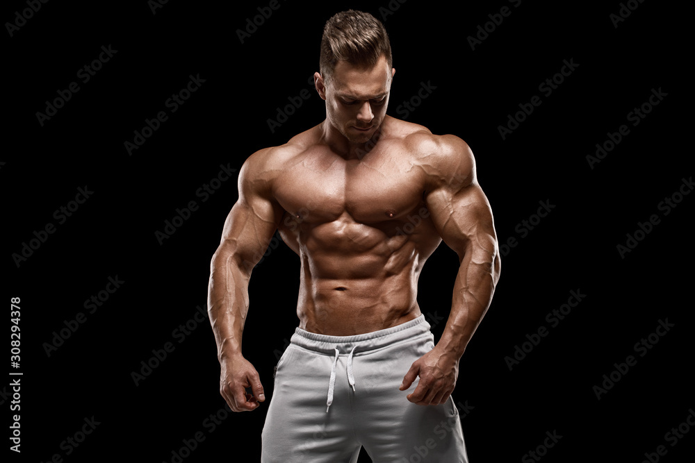 Muscular man showing muscles isolated on the black background. Strong male naked torso abs Muscular man showing muscles isolated on the black background. Strong male naked torso abs