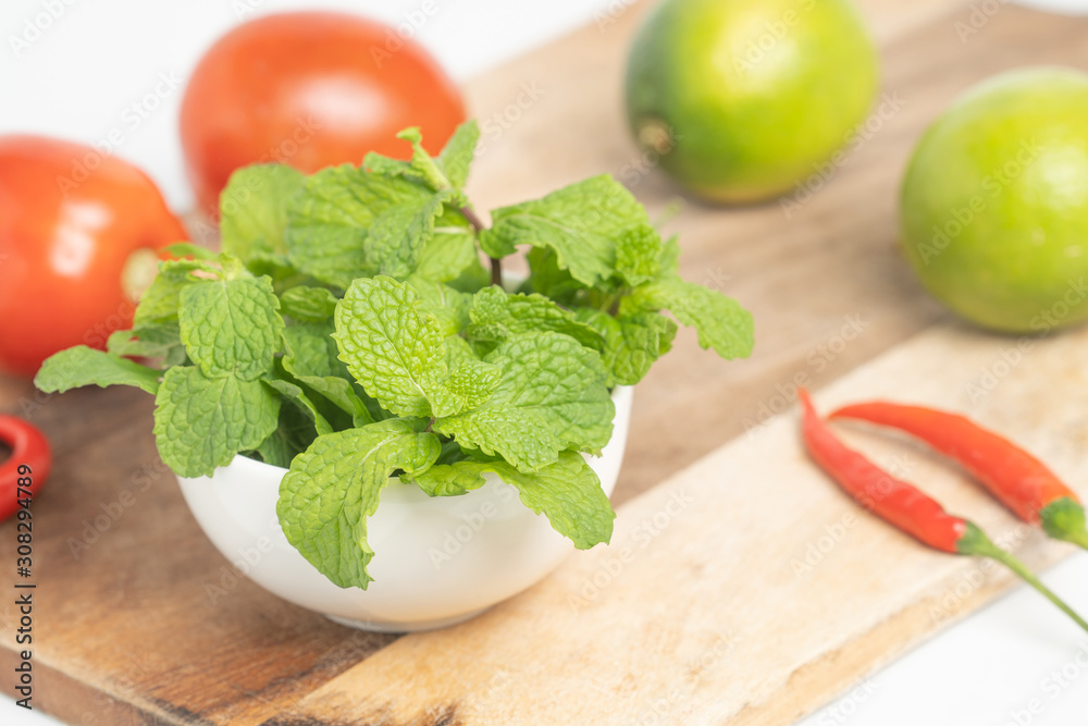 peppermint in small cup on board and Vegetable with white background peppermint in small cup on board and Vegetable with white background