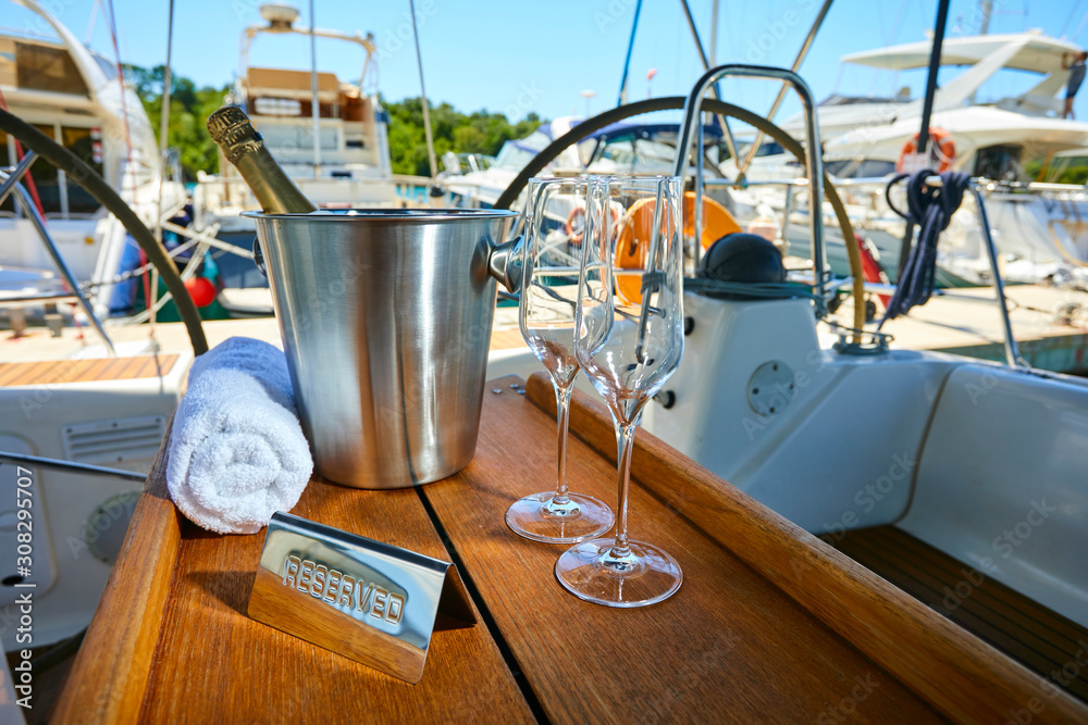 Romantic luxury evening on cruise yacht with champagne setting. Empty glasses and bottle with champagne and tropical sunset with sea background