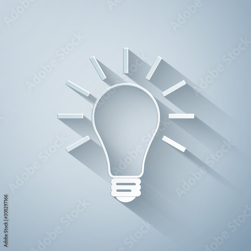 Fototapeta Naklejka Na Ścianę i Meble -  Paper cut Light bulb with rays shine icon isolated on grey background. Energy and idea symbol. Lamp electric. Paper art style. Vector Illustration
