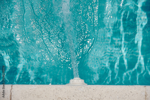 spout pouring water into a pool with crystal clear water photo