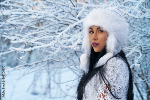 Fototapeta Naklejka Na Ścianę i Meble -  Girl in warm hat on background of trees with snow.