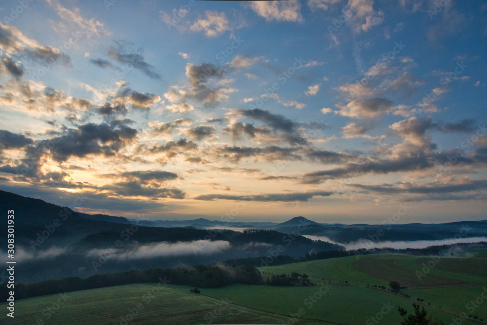 Fototapeta premium Faszinierende, beeindruckende Morgenstimmung mit Nebel über den Elbe, Täler im Nationalpark Sächsische Schweiz. Blick von der Kaiserkrone auf Zirkelstein, Rosenberg, Schrammsteine bis Lilienstein.