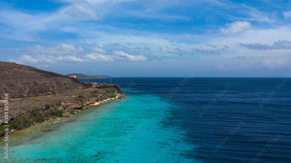 Aerial view of coast of Curaçao in the Caribbean Sea with turquoise water, cliff, beach and beautiful coral reef around St.Martha Bay